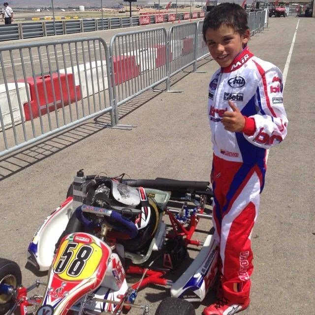VMotorsport driver standing beside kart number 58 in the pit lane