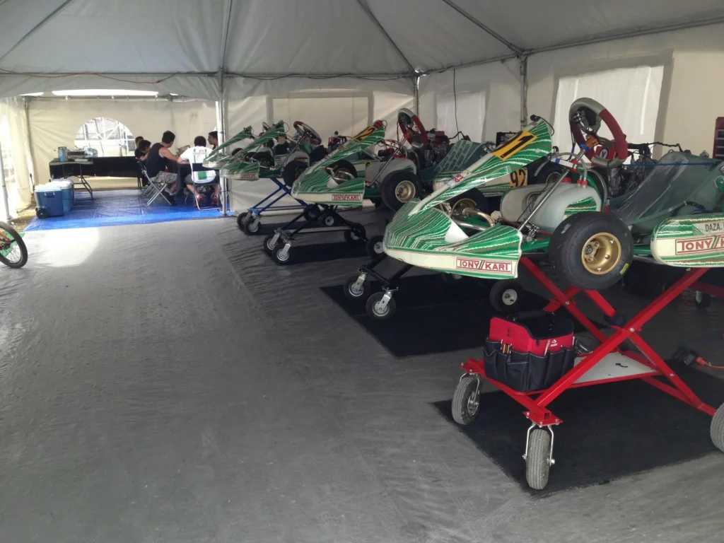 Race karts lined up under the VMotorsport paddock tent at the track