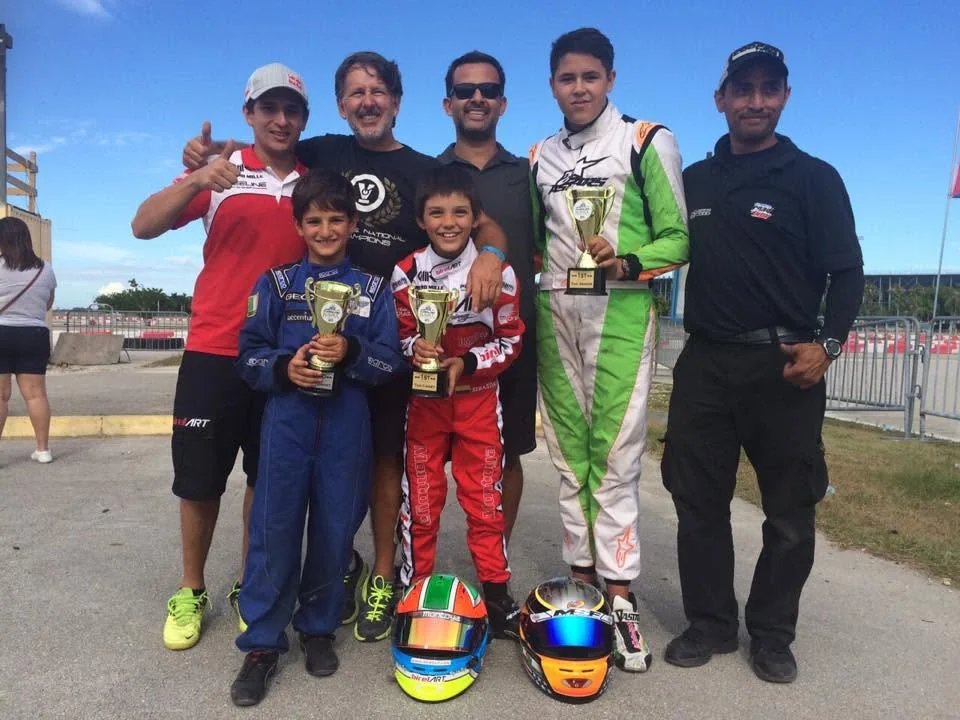 VMotorsport drivers and crew with their trophies at the track