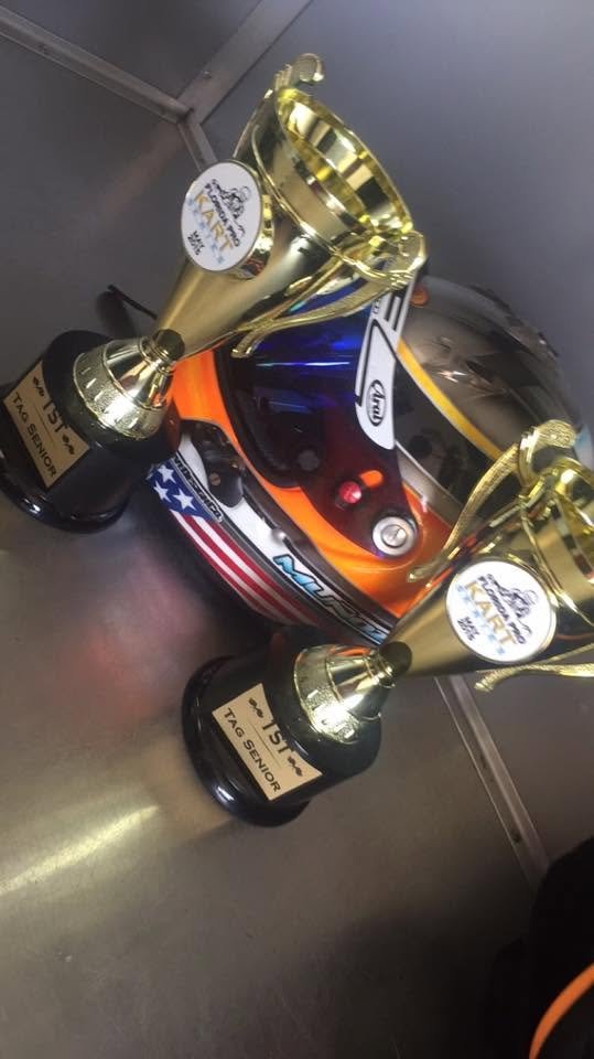 Gold trophies resting on a racing helmet