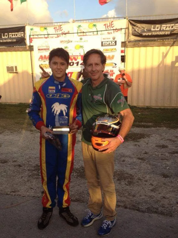 A young VMotorsport driver with his trophy and helmet after a race